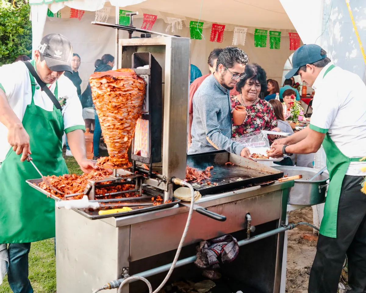 Vendedor callejero preparando tacos al pastor sobre el trompo